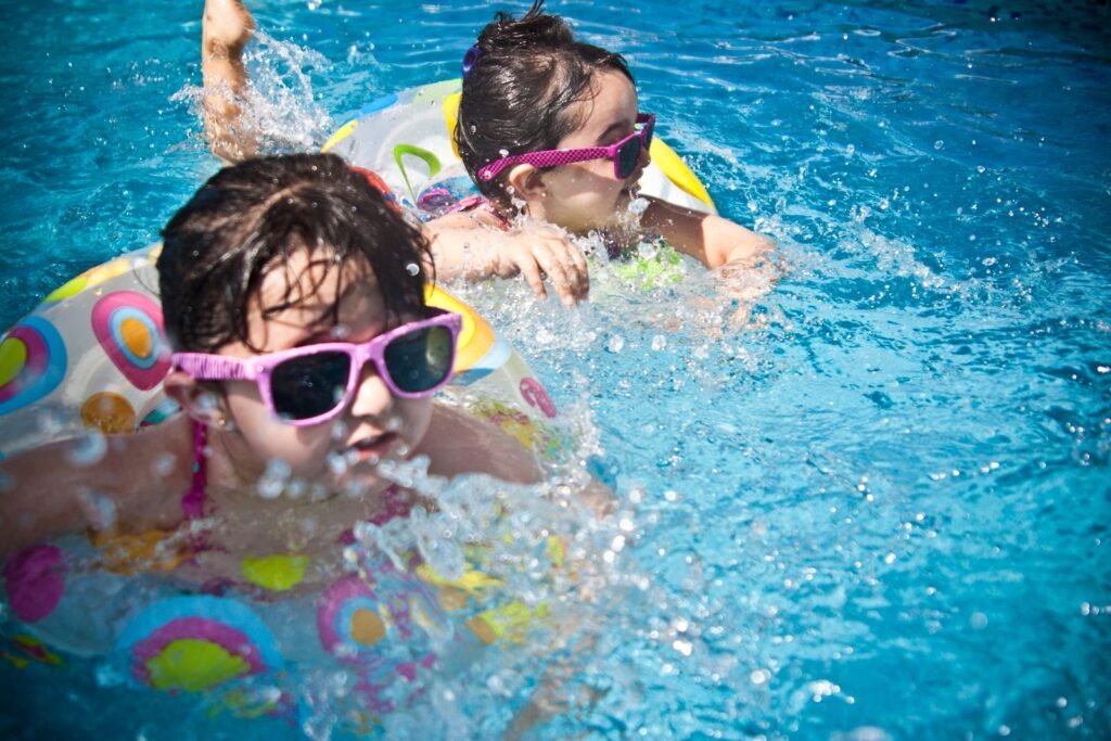 Kinderen met zwembril spelen in het zwembad na het reserveren van een dagentree in De Vossemeren